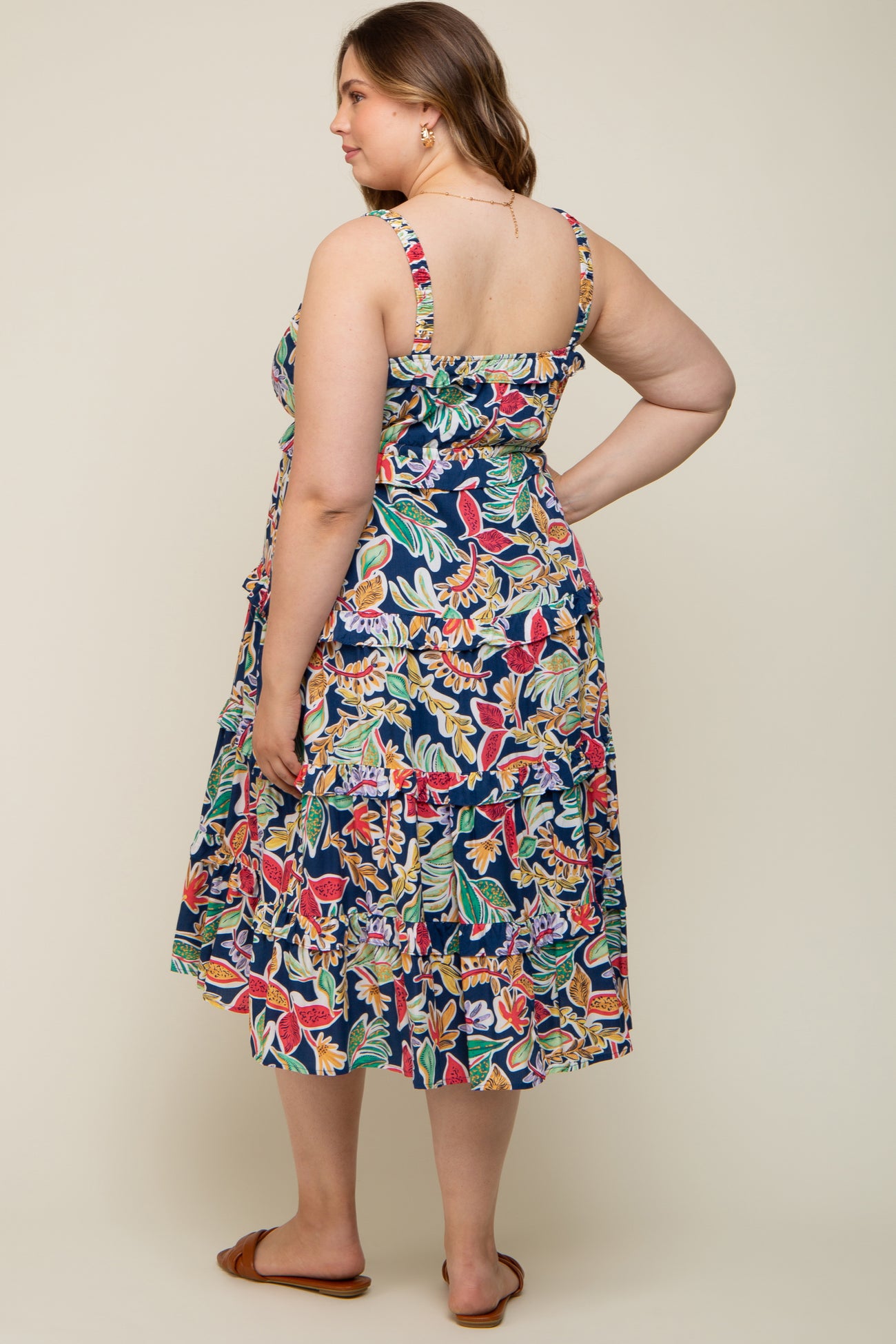 woman wearing a floral print maternity plus maxi dress with adjustable straps, showing a side view and back detail