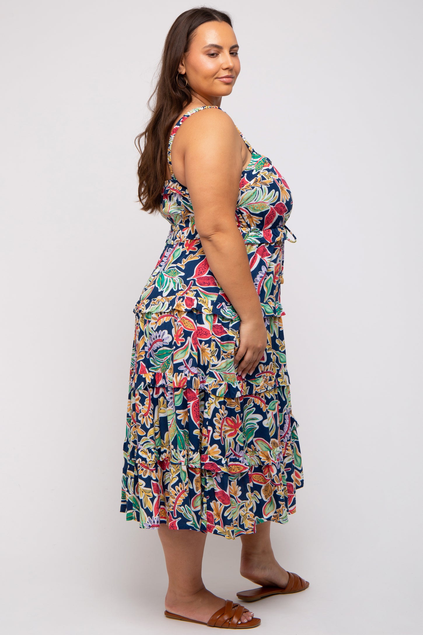 woman wearing a colorful floral print plus-size sundress with a tiered skirt and adjustable straps