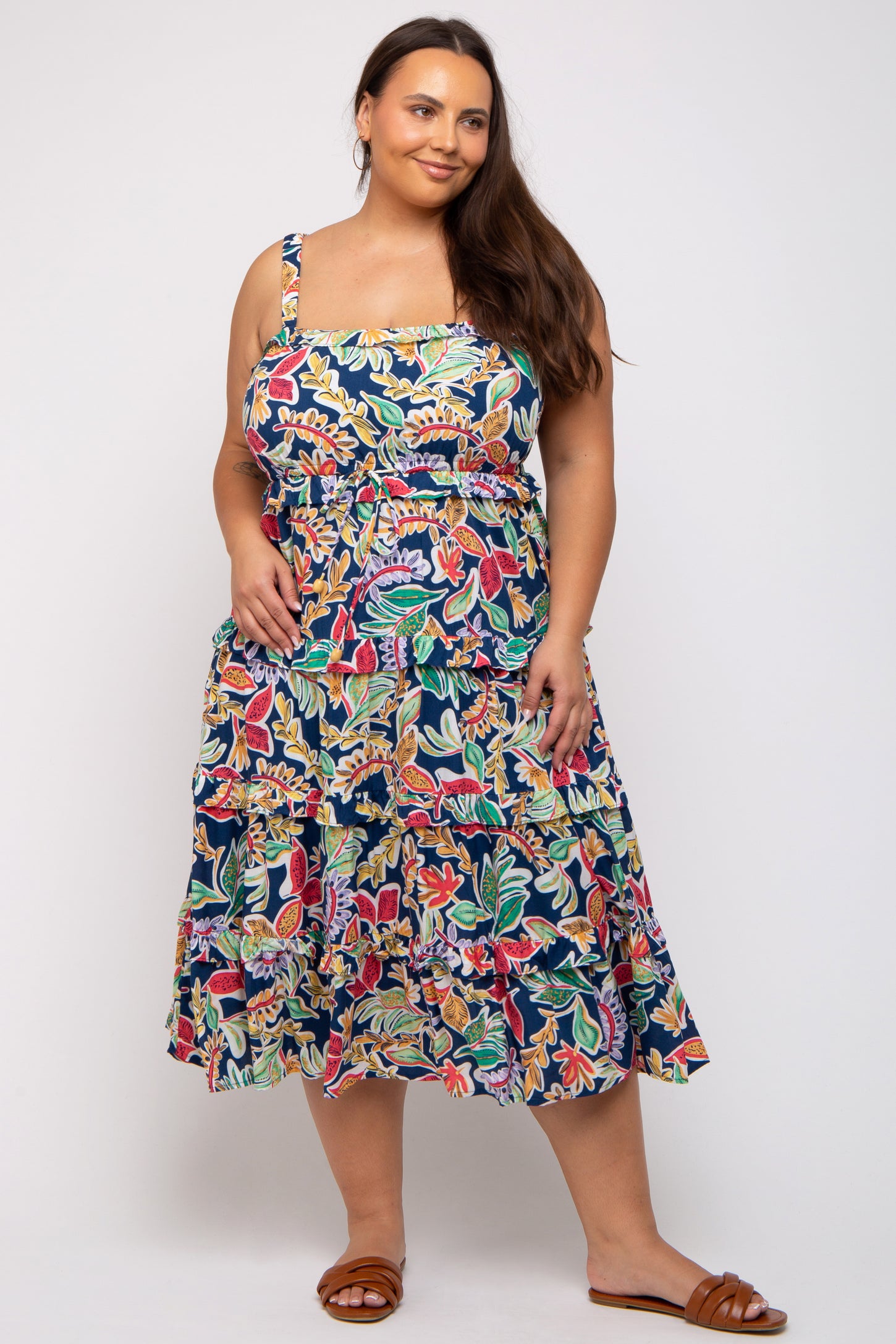 woman wearing a navy blue floral plus size sundress with spaghetti straps and a flared skirt