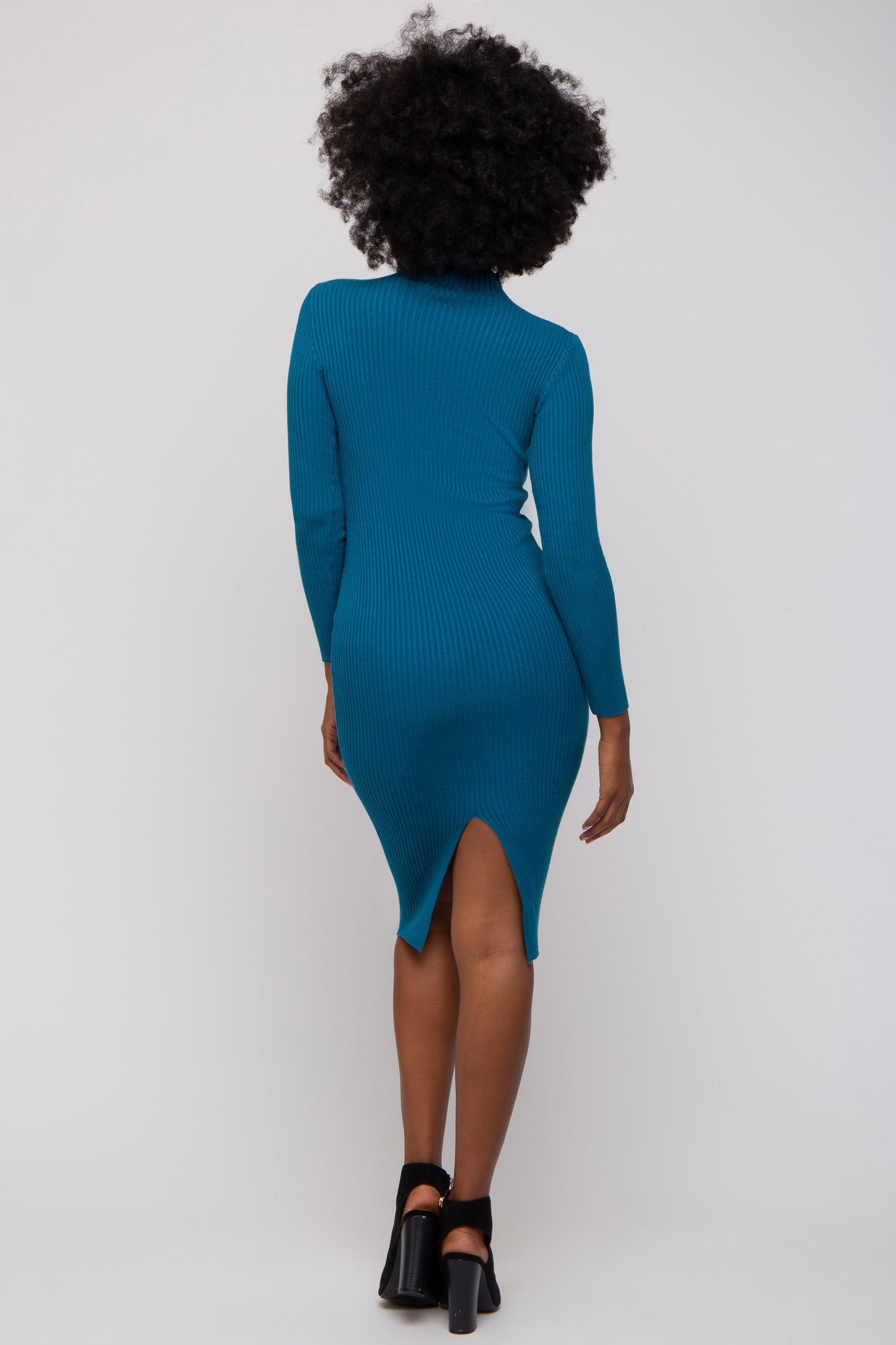 woman wearing a teal ribbed bodycon dress with long sleeves and a side slit, shown from the back