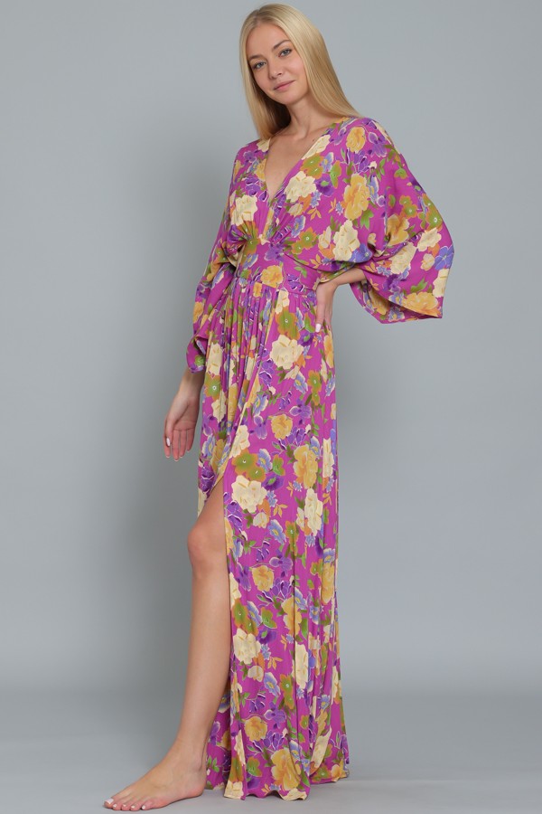 woman wearing a purple floral maxi dress with balloon sleeves and a high slit