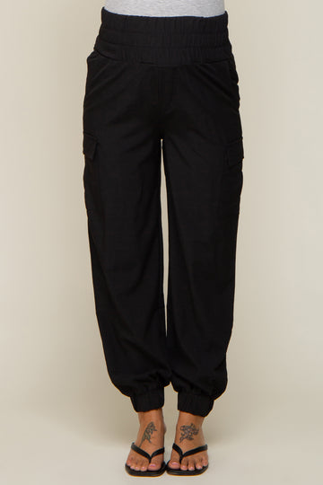 woman wearing black maternity cargo pants with an elastic waistband and tapered ankle cuffs