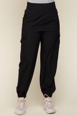 person wearing black high-waisted cargo jogger pants with elastic waistband and side pockets
