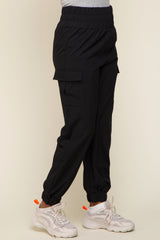 woman wearing black cargo joggers with side pockets and elastic cuffs, paired with white sneakers