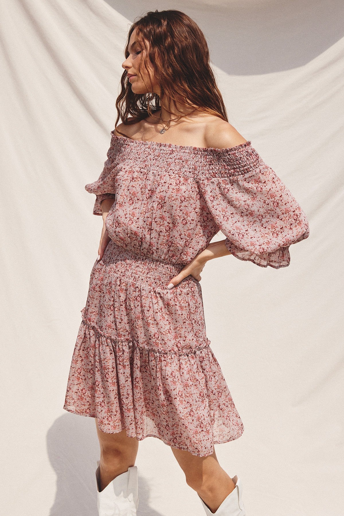 woman wearing a floral off-the-shoulder dress with puff sleeves and a smocked waist