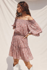 woman wearing a floral off-the-shoulder dress with puff sleeves and a smocked waist