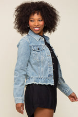 woman wearing a light blue denim jacket with frayed hem and styled with a black dress