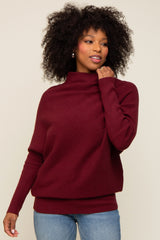 woman wearing a burgundy cozy turtleneck sweater paired with blue jeans