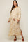 Smiling pregnant woman wearing a cream and yellow ikat print maternity maxi dress with long sleeves and tassels