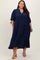 woman wearing a navy blue tiered midi dress with three-quarter sleeves and a v-neckline in plus size