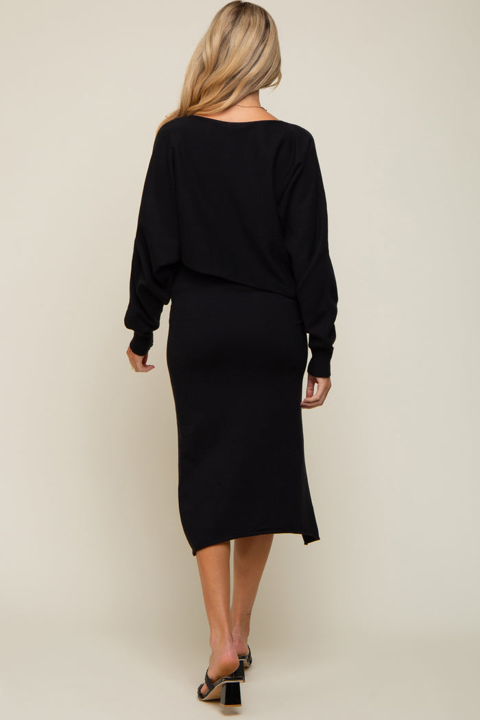 woman wearing a black maternity dress with a relaxed fit and long sleeves, showing a baby bump from the back