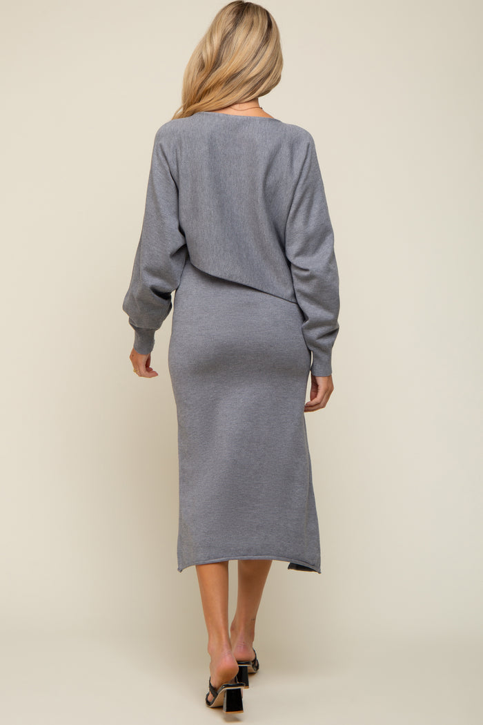 woman wearing a grey maternity sweater dress with long sleeves and a fitted silhouette, displaying a casual look from the back