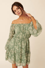 woman wearing a green off-the-shoulder floral print dress with puffed sleeves and tiered ruffles