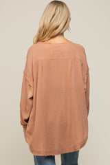 Back view of a woman wearing a mauve oversized gauze top with raw hem and waffle knit sleeves