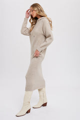 woman wearing a beige hooded knit midi dress and white knee-high boots, posing sideways with a relaxed stance