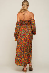 woman wearing a floral off-shoulder maxi maternity dress with long sleeves and a fitted bodice