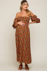 woman wearing a floral off-shoulder maternity maxi dress and holding her baby bump