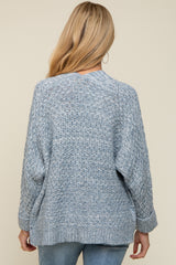 woman wearing a light blue knitted maternity sweater with a relaxed fit and long sleeves, seen from the back