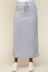 woman wearing a grey maxi skirt with pockets and drawstring waist, paired with white sneakers