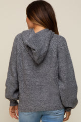 woman wearing a gray maternity hoodie sweater with a relaxed fit and a hood, viewed from the back