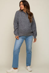 woman wearing a gray maternity sweater with puff sleeves and light blue maternity jeans