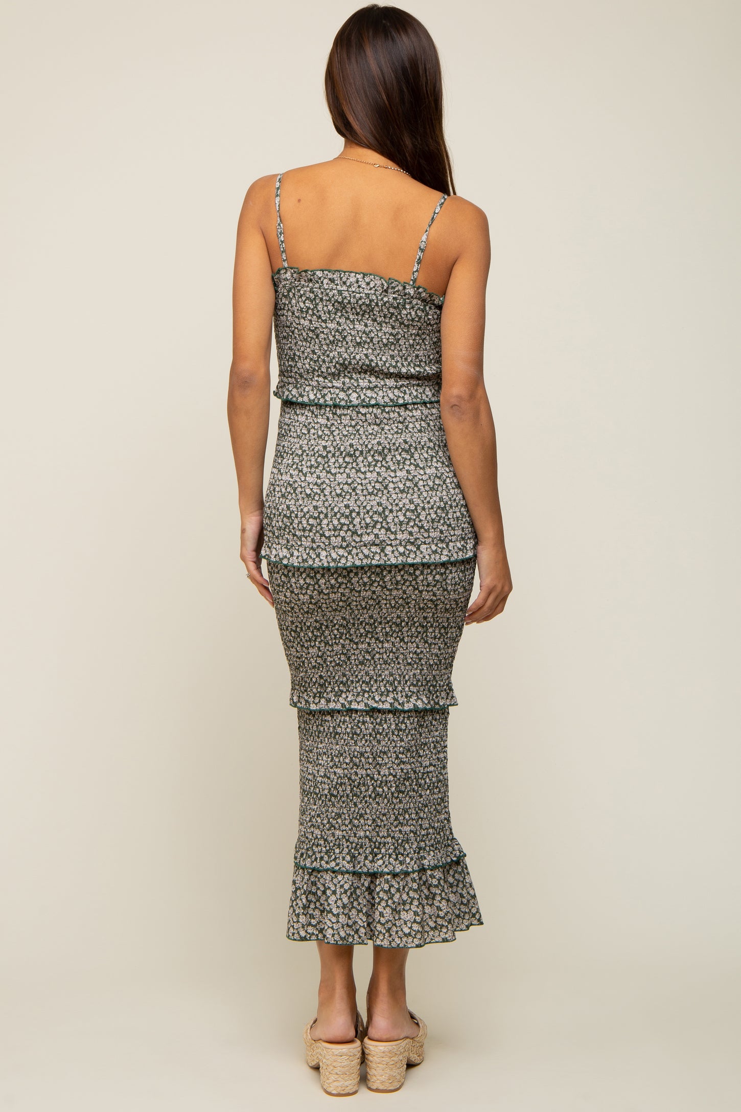 woman wearing a black and white floral print maternity dress with tiered ruffles and spaghetti straps