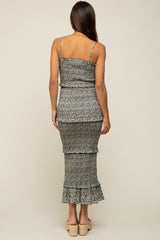 woman wearing a black and white floral print maternity dress with tiered ruffles and spaghetti straps