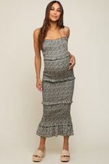 woman wearing a floral maternity dress with ruffle tiers and a visible baby bump, styled with espadrille sandals