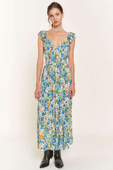 woman wearing a floral print maxi dress with ruffled sleeves and a fitted bodice in shades of blue, green, and yellow