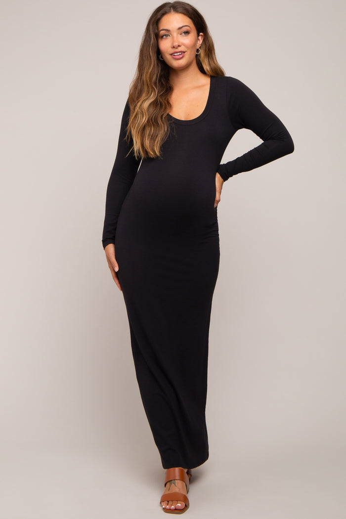 woman wearing a black long sleeve maternity maxi dress and showing her baby bump