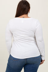 woman wearing a white long sleeve plus size top, showing a fitted style and sleek back view while paired with blue jeans