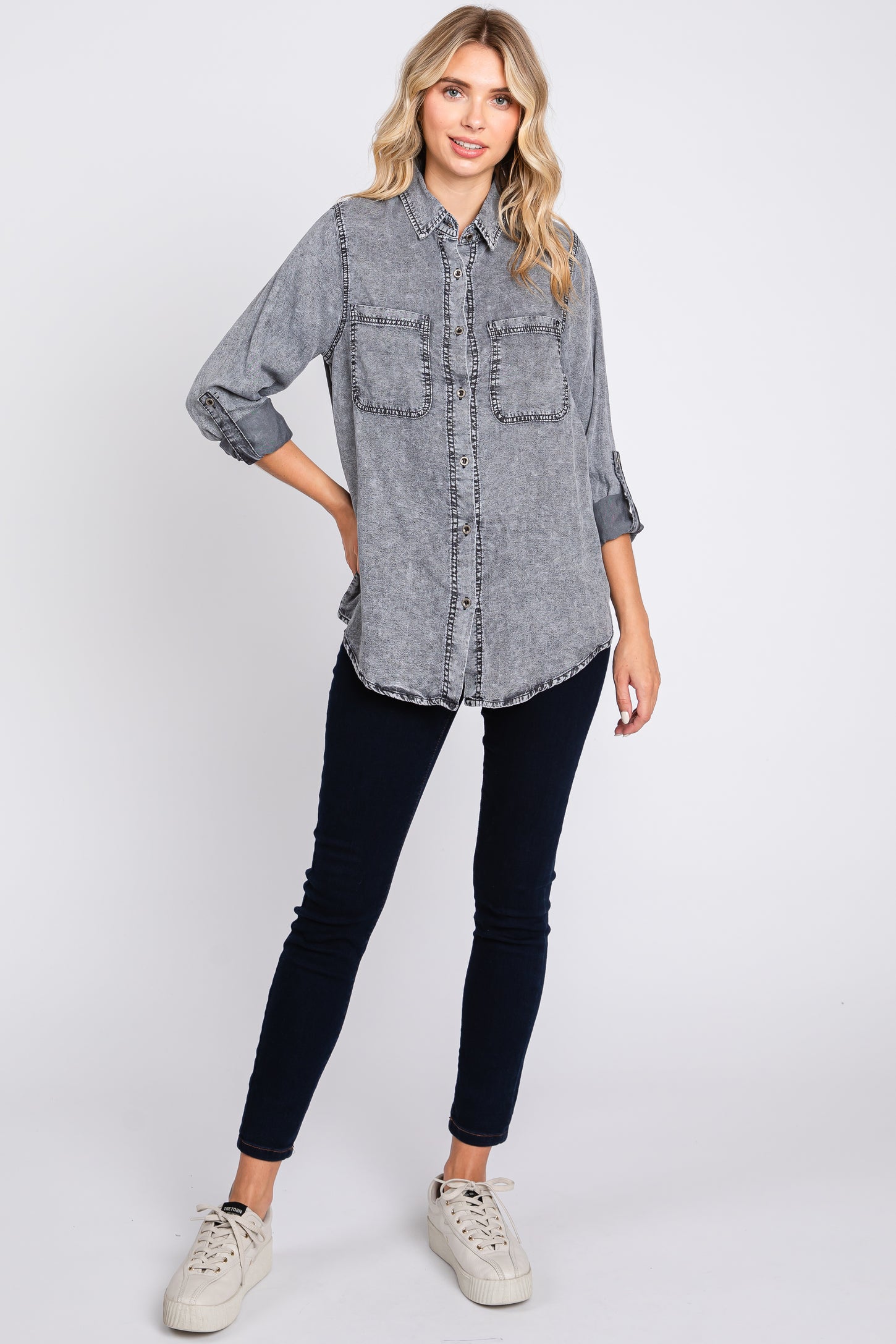 woman wearing a gray denim button-up shirt with two front pockets and black skinny jeans