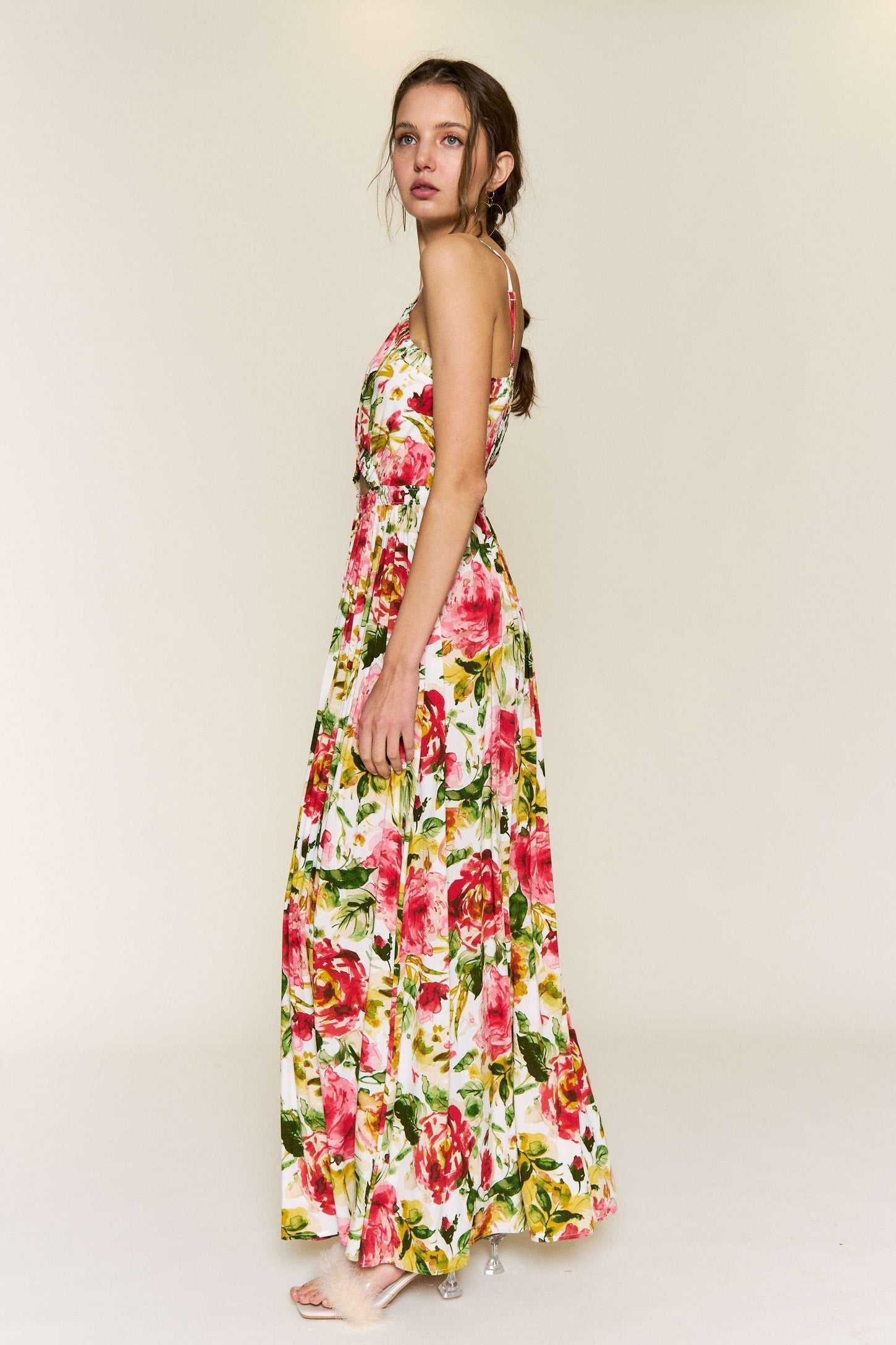 woman wearing a floral maxi dress with pink and yellow roses, styled with a flowy silhouette and adjustable straps