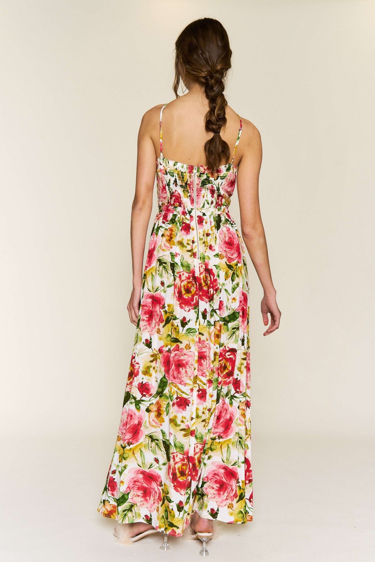 woman wearing a floral maxi dress with pink roses and a fitted bodice, view from the back