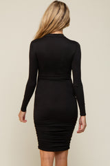 woman wearing a black long sleeve maternity dress with ruching details on the sides