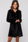 woman wearing a black velvet long-sleeve button-up dress with a relaxed fit and full skirt