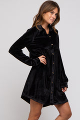 woman wearing a black velvet long sleeve button-up dress with a relaxed fit and a rounded hem
