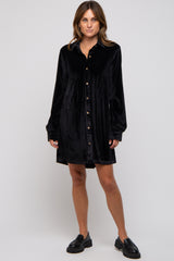 woman wearing a black velvet button-up shirt dress with long sleeves and a relaxed fit
