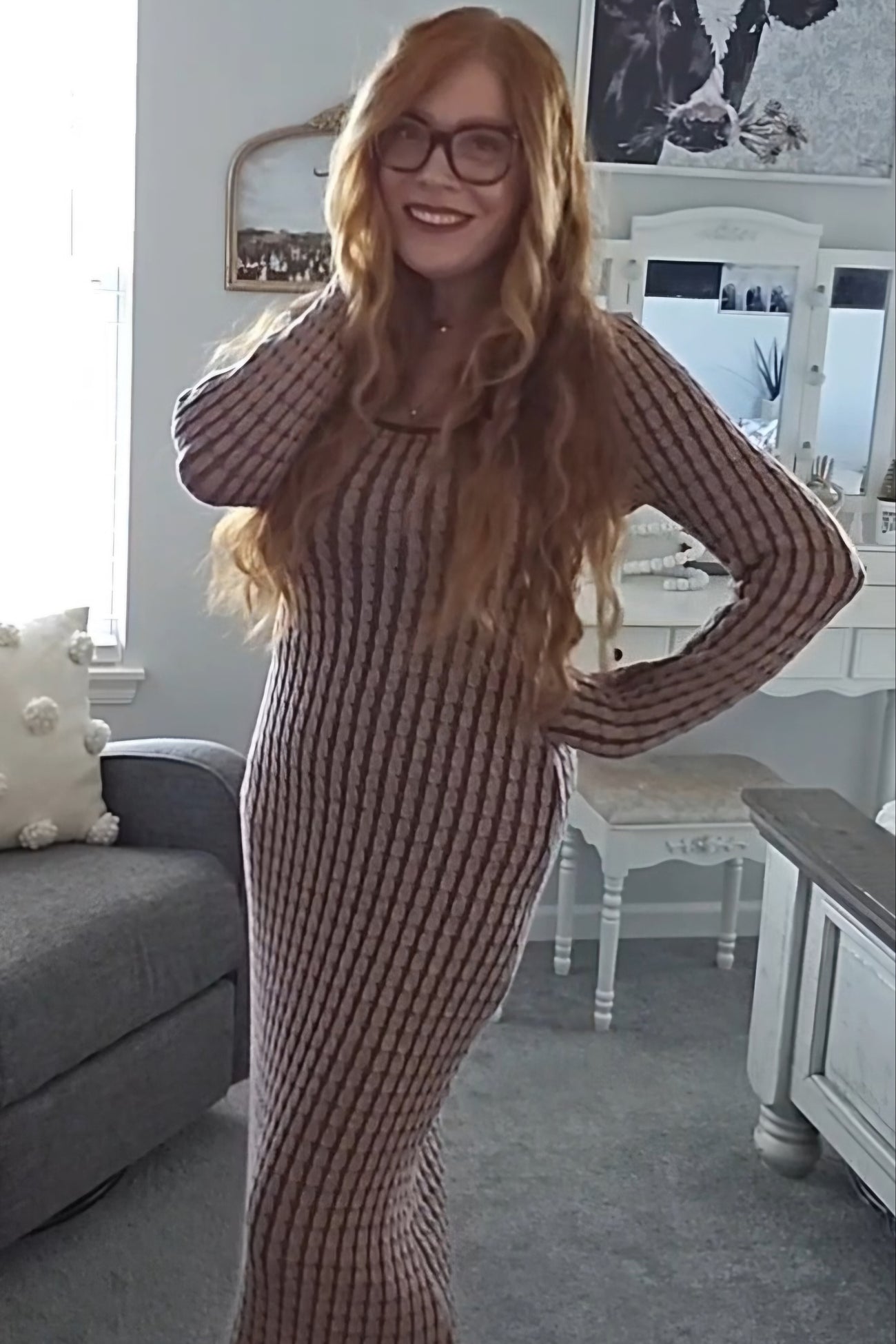 woman wearing a ribbed long sleeve maxi dress in brown and beige stripes, posing with long wavy hair and glasses