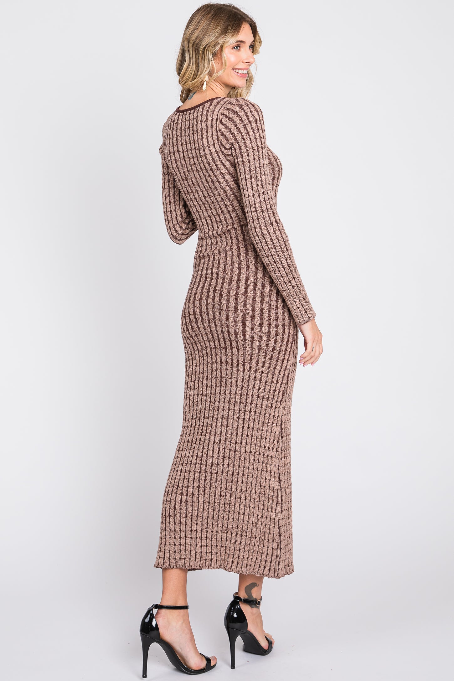 woman wearing a brown ribbed long sleeve maxi dress with a fitted silhouette and side slit, viewed from the back