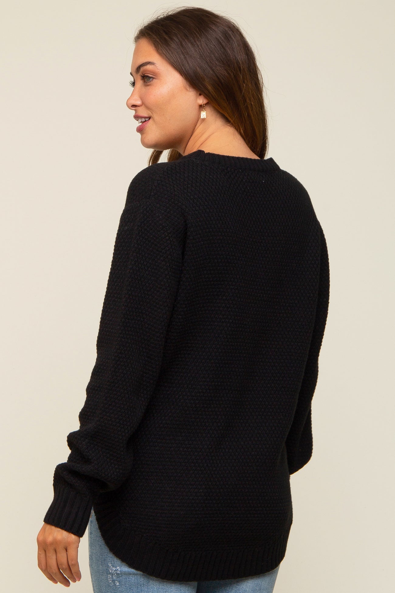 woman wearing a black knitted maternity sweater, shown from the back with long sleeves and a relaxed fit