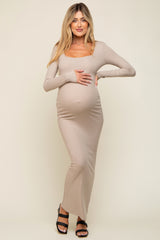 woman wearing a nude long sleeve ribbed maternity dress and holding her baby bump