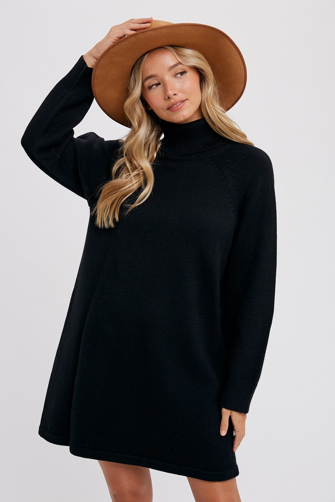 woman wearing a black turtleneck sweater dress and a tan wide-brim hat