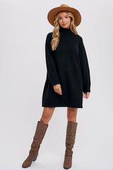 woman wearing a black turtleneck sweater dress with long sleeves and brown knee-high boots, styled with a wide-brimmed hat