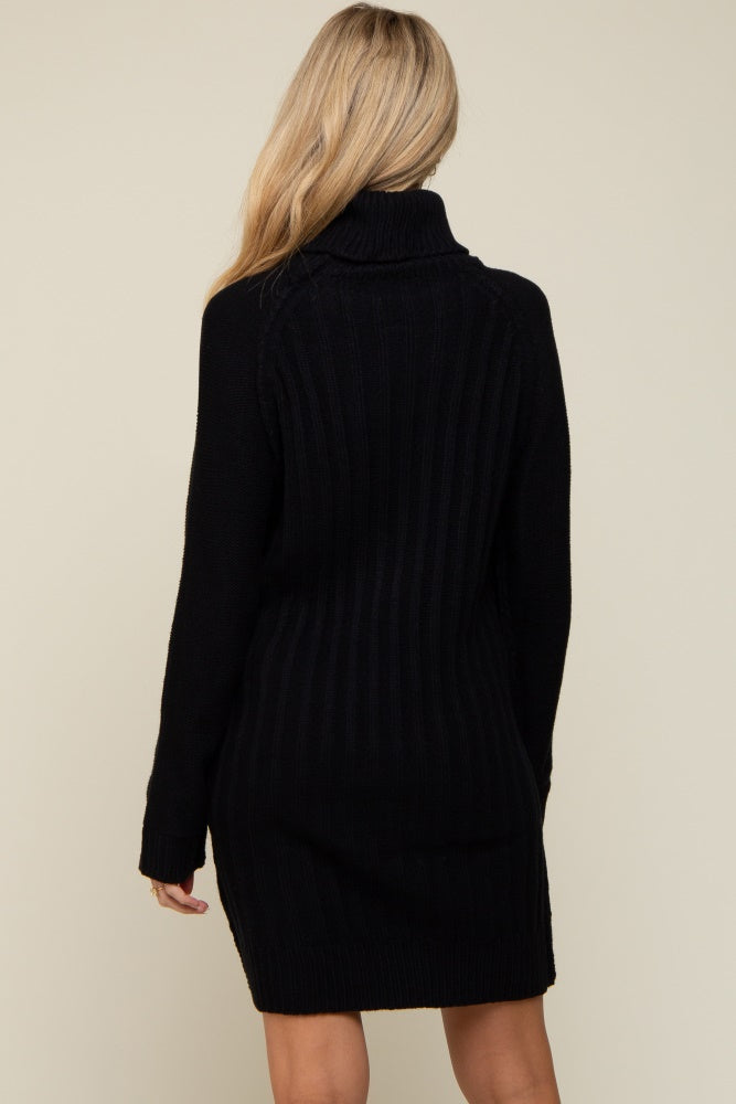 woman wearing a black ribbed maternity sweater dress with a high collar and long sleeves, showing a neutral background