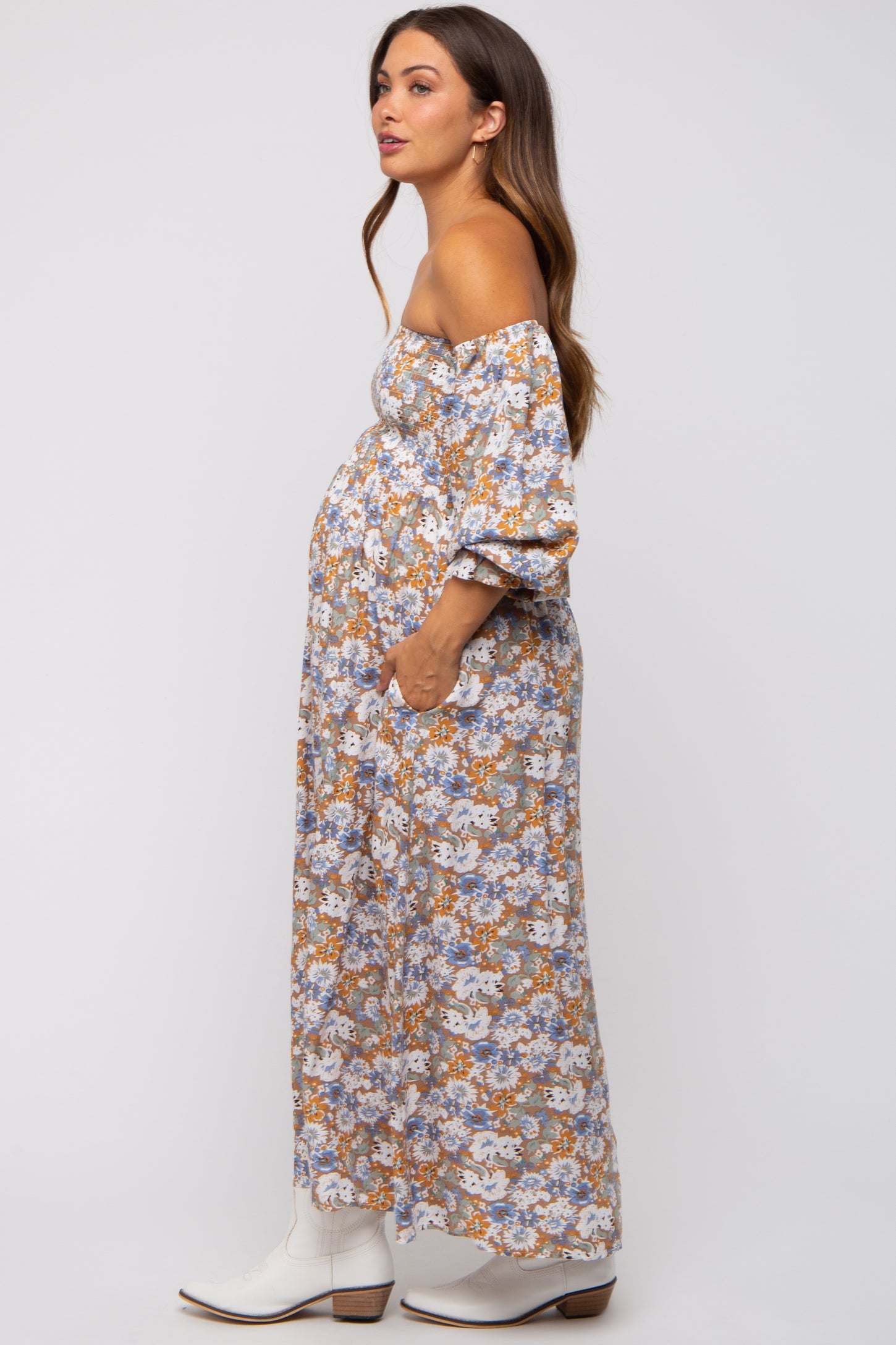 woman wearing a floral off-the-shoulder maternity maxi dress with a visible baby bump