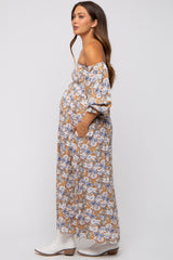 woman wearing a floral off-the-shoulder maternity maxi dress with a visible baby bump