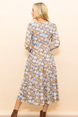 woman wearing a floral long sleeve midi dress with a fitted bodice and flowing skirt, seen from the back