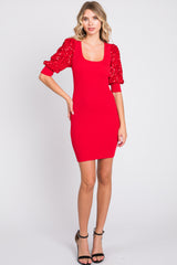 woman wearing a red ribbed mini dress with balloon sleeves adorned with sequins