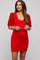 woman wearing a red ribbed maternity dress with sequin puff sleeves and holding sunglasses, showing her baby bump